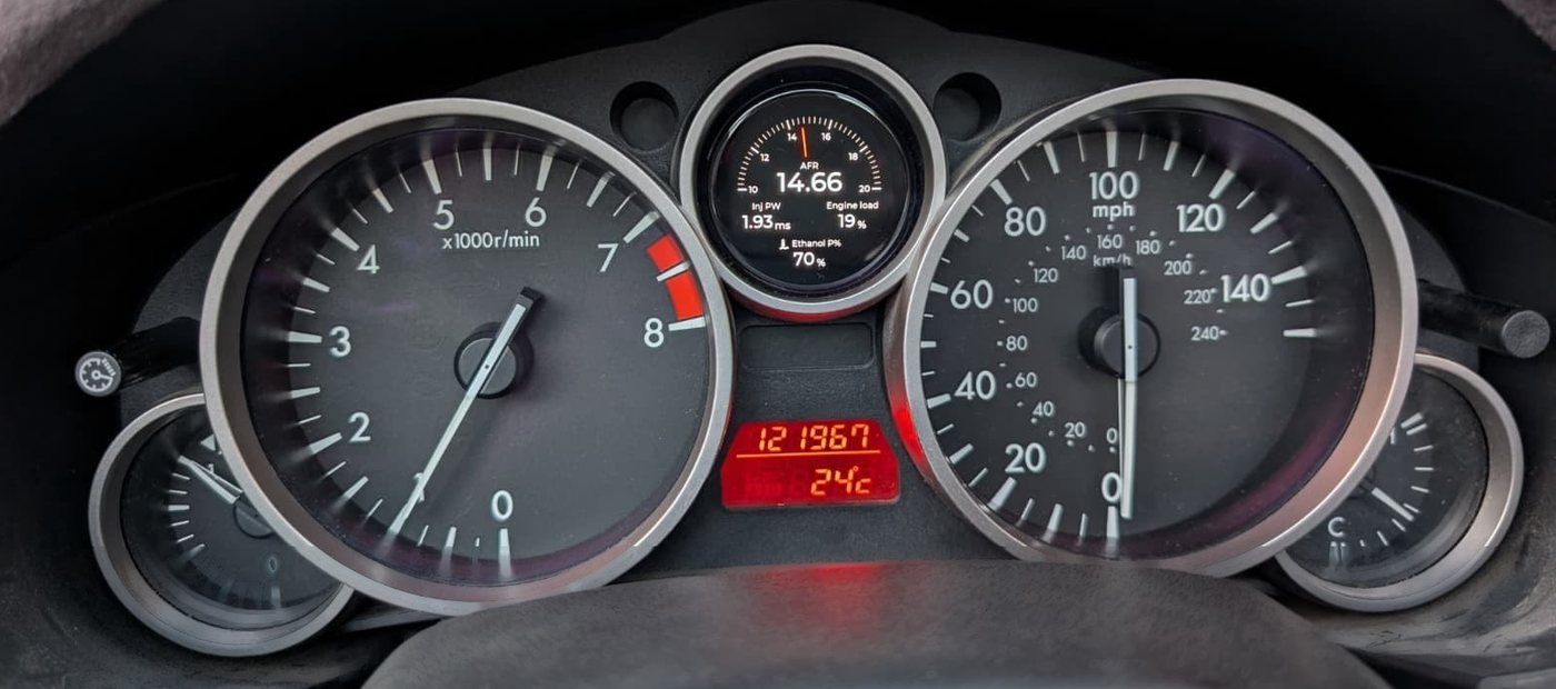 Combiné d'une Mazda MX-5 NC : le compte-tours et le compteur de
              vitesse d'origine encadrent le CanDash, installé à la place du
              cadran central, qui affiche AFR 14,66 et 70 % d'éthanol.